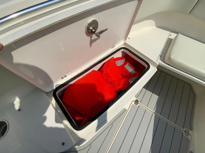 Slide: The Image of Storage compartment with life jackets on a 2013 Cobia 296 Center Console boat. - 32