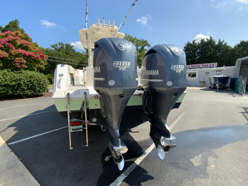 Slide: The Image of 2013 Cobia 296 Center Console with twin Yamaha 300 engines in a parking lot. - 8