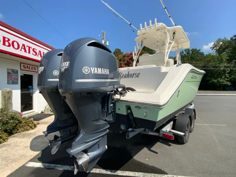 Slide: The Image of 2013 Cobia 296 Center Console boat with twin Yamaha engines at a sales lot. - 9