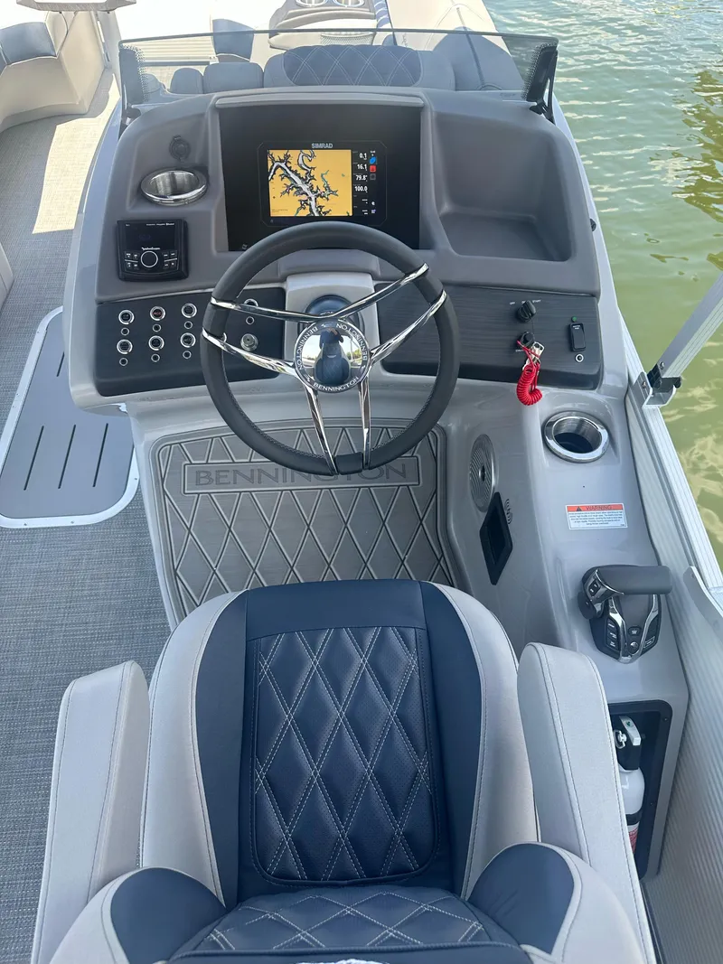 Slide: The Image of 2025 Bennington 23 RSR boat dashboard with steering wheel and navigation display. - 10