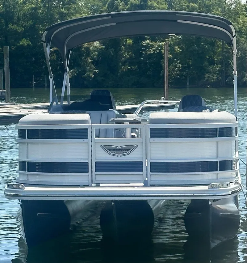 Slide: The Image of 2025 Bennington 23 RSR pontoon boat on calm water, featuring a sleek design and canopy. - 4