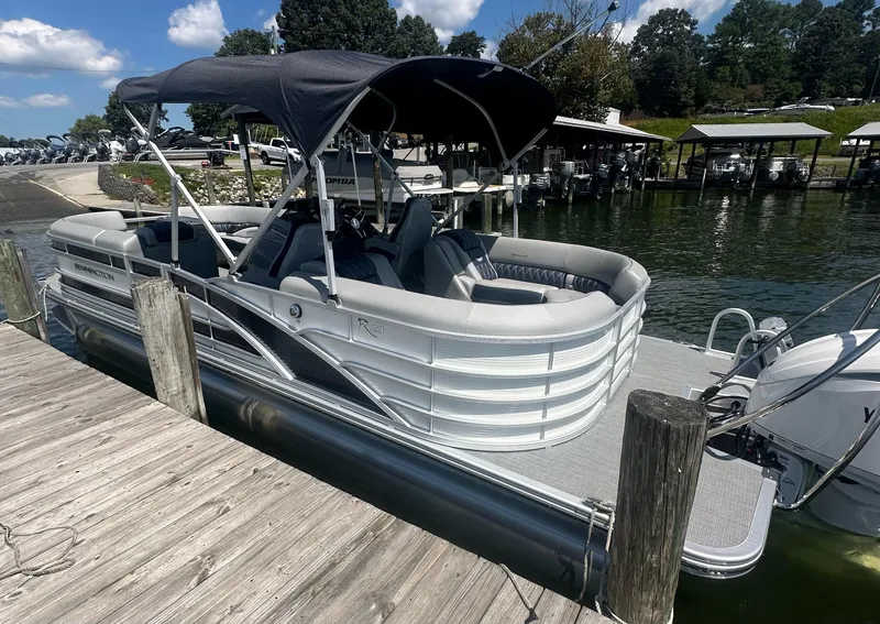 Slide: The Image of 2025 Bennington 23 RSR pontoon boat docked by a wooden pier on a sunny day. - 5