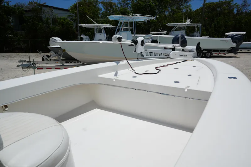 Slide: The Image of 2013 Renegade Nomad 22 boat on trailer, surrounded by other boats, in a sunny outdoor setting. - 2
