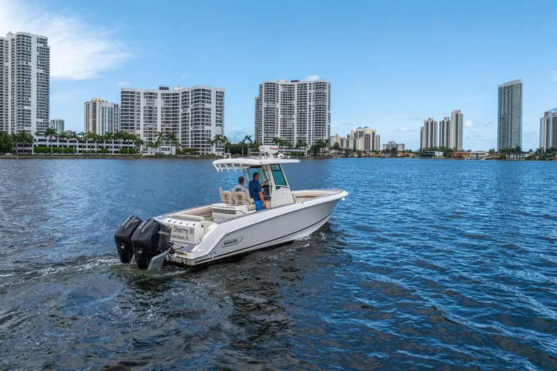 Slide: The Image of 2018 Boston Whaler 280 Outrage cruising near city skyline on calm water. - 15