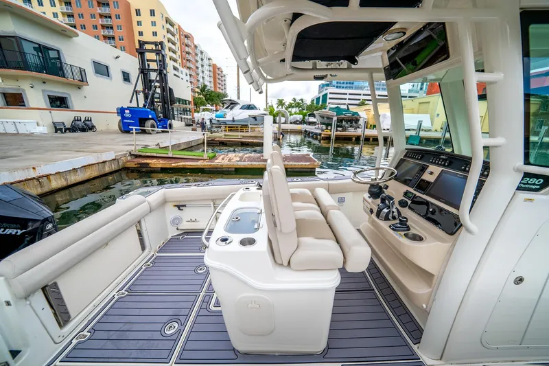 Slide: The Image of 2018 Boston Whaler 280 Outrage boat interior at marina, featuring helm and seating area. - 24