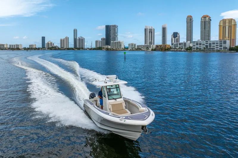 Slide: The Image of 2018 Boston Whaler 280 Outrage cruising near city skyline on a sunny day. - 6