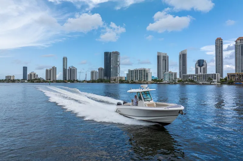 Slide: The Image of 2018 Boston Whaler 280 Outrage cruising near city skyline on a sunny day. - 8
