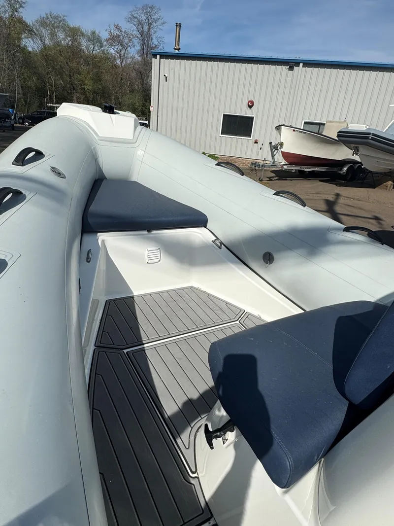 Slide: The Image of 2023 Brig Navigator 485 boat interior with blue seating and gray flooring. - 2