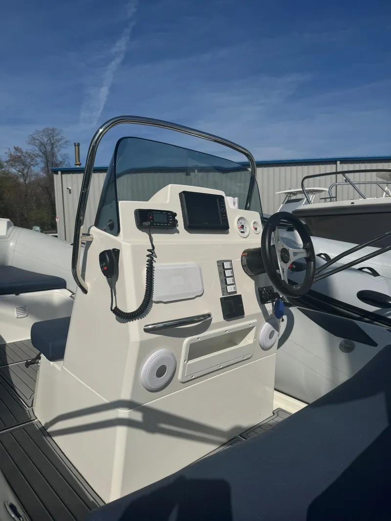 Slide: The Image of 2023 Brig Navigator 485 boat console with steering wheel and navigation equipment. - 6