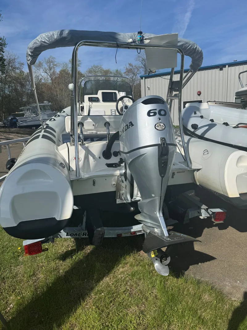 Slide: The Image of 2023 Brig Navigator 485 boat with Honda 60 outboard motor, parked outdoors. - 7