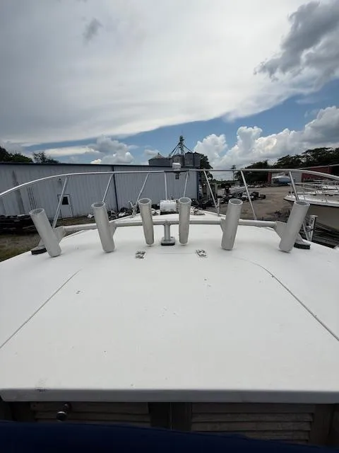Slide: The Image of 1986 Blackfin 27 boat deck with rod holders, docked under a cloudy sky. - 13
