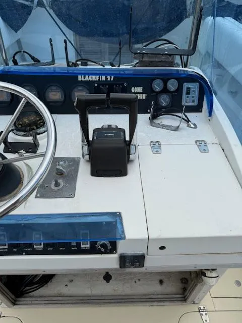 Slide: The Image of 1986 Blackfin 27 boat dashboard with steering wheel and control panel. - 17