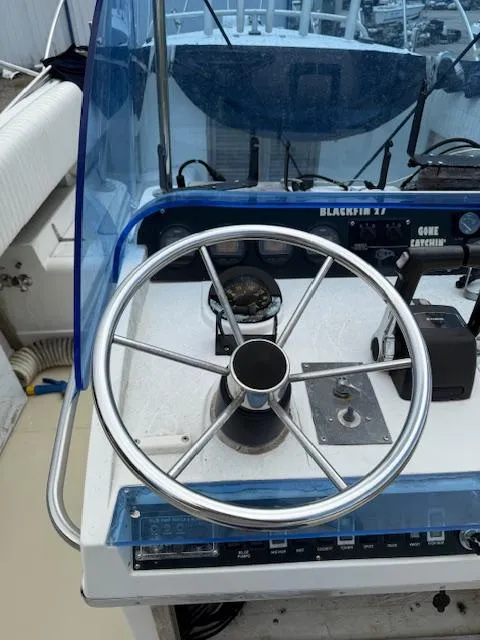 Slide: The Image of 1986 Blackfin 27 boat helm with steering wheel and navigation instruments. - 18