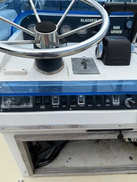 Slide: The Image of Control panel of a 1986 Blackfin 27 boat with steering wheel and switches. - 19