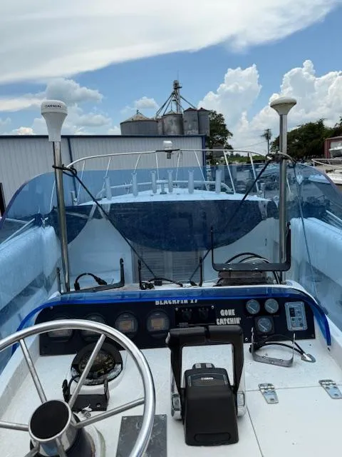 Slide: The Image of 1986 Blackfin 27 boat cockpit with steering wheel, navigation equipment, and clear blue sky. - 20