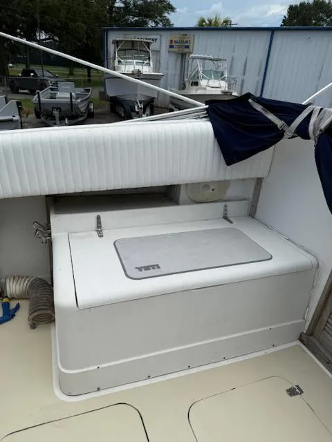 Slide: The Image of 1986 Blackfin 27 boat interior with storage compartment and cushioned seating. - 29