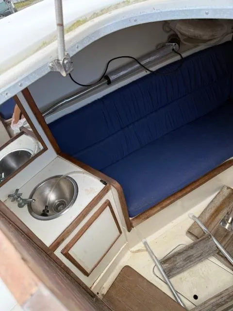Slide: The Image of 1986 Blackfin 27 boat interior with blue seating and small sink. - 5