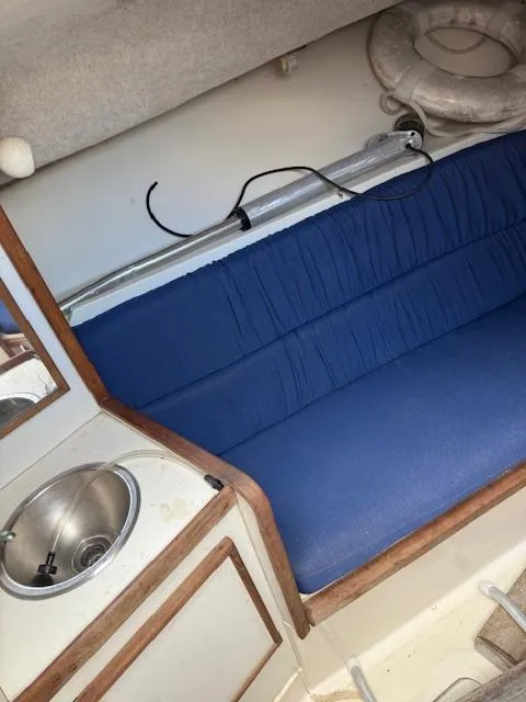 Slide: The Image of 1986 Blackfin 27 interior with blue seating, sink, and life preserver. - 7