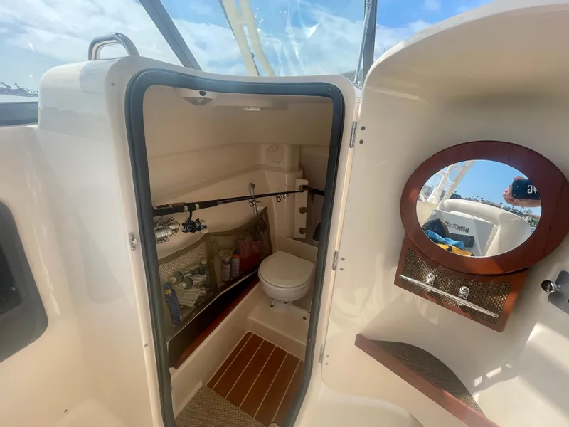 Slide: The Image of 2015 Grady-White 275 Freedom boat interior with bathroom and fishing rod storage. - 10