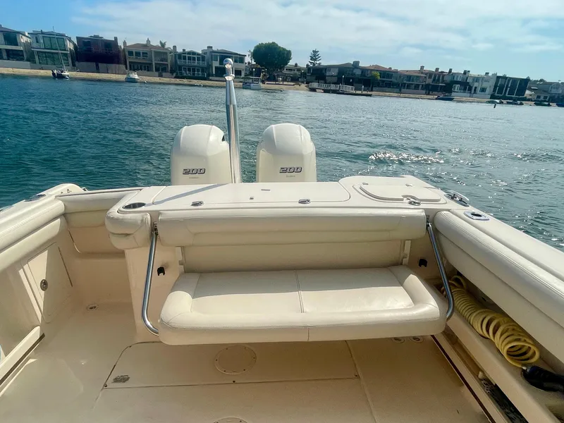 Slide: The Image of 2015 Grady-White 275 Freedom boat with dual engines, docked near waterfront homes. - 13