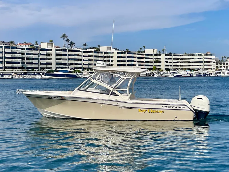 Slide: The Image of 2015 Grady-White 275 Freedom boat on water, with buildings in the background. - 2