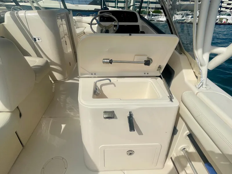 Slide: The Image of 2015 Grady-White 275 Freedom boat interior with sink and steering wheel. - 25