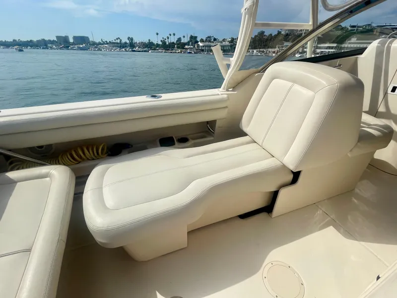 Slide: The Image of 2015 Grady-White 275 Freedom boat interior with beige seating, dockside view. - 6