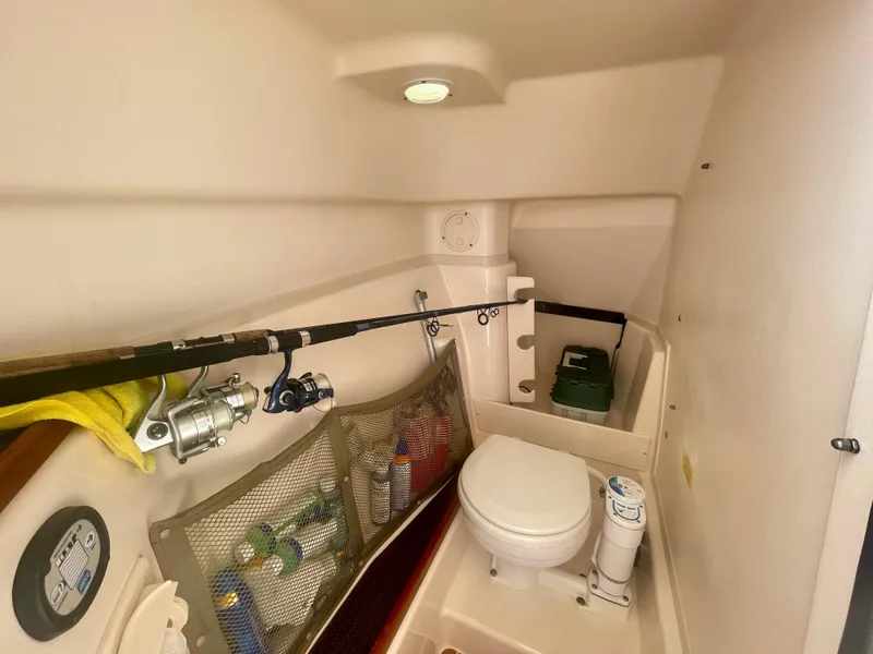 Slide: The Image of 2015 Grady-White 275 Freedom boat interior with fishing gear and compact toilet. - 9