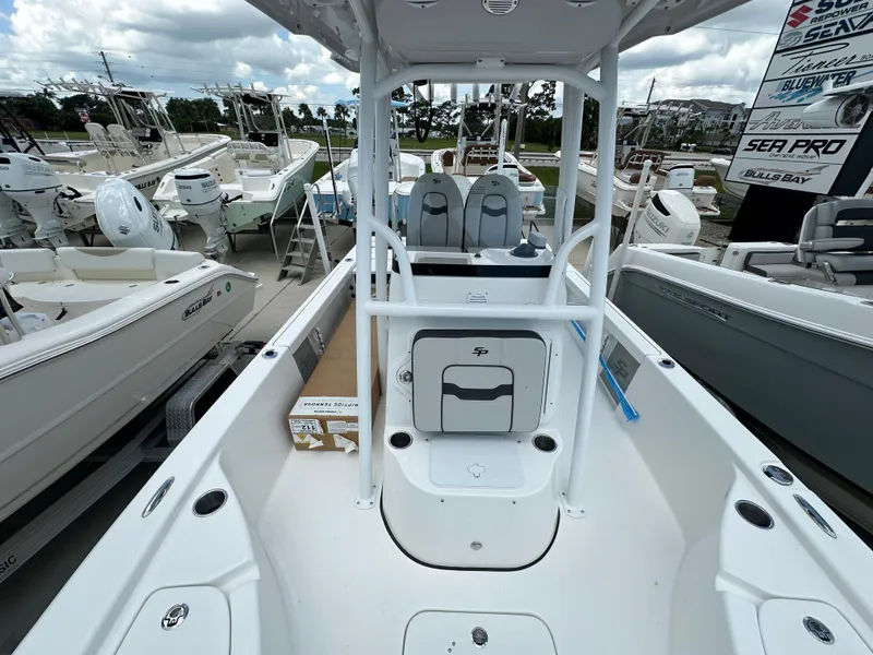 Slide: The Image of 2026 Sea Pro 230 Bay boat interior, showcasing seating and storage, surrounded by other boats. - 11