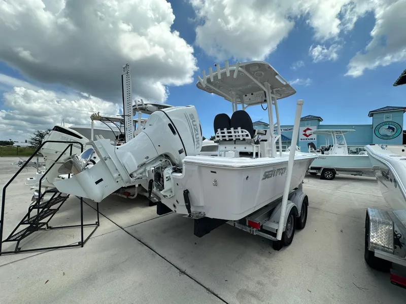 Slide: The Image of 2026 Sea Pro 230 Bay boat with Suzuki engine on trailer under cloudy sky. - 3