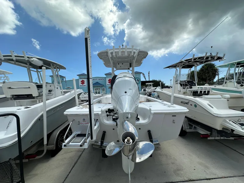 Slide: The Image of 2026 Sea Pro 230 Bay boat with outboard motor, displayed at a dealership under a cloudy sky. - 4