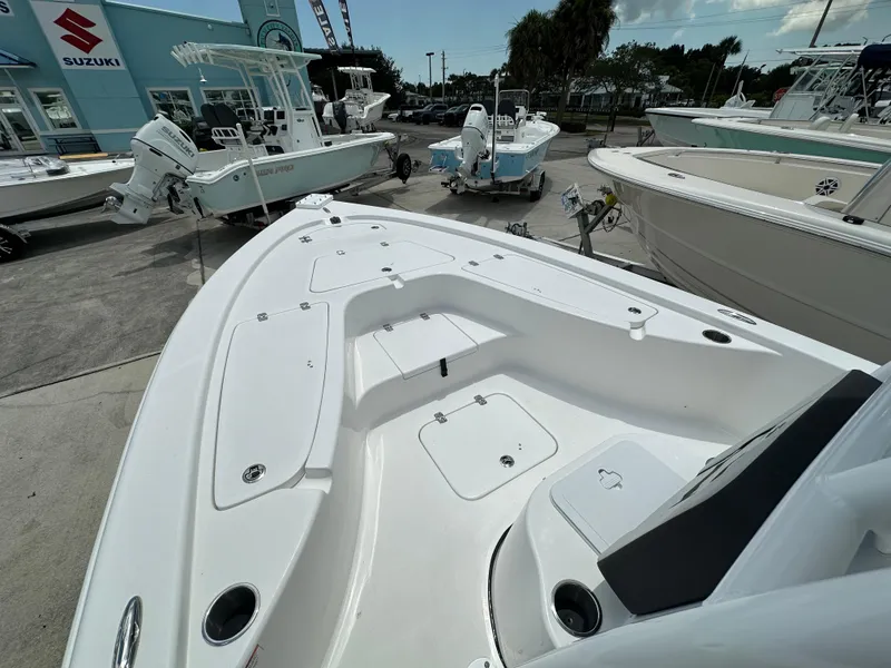 Slide: The Image of 2026 Sea Pro 230 Bay boat displayed at a dealership with Suzuki engines. - 6