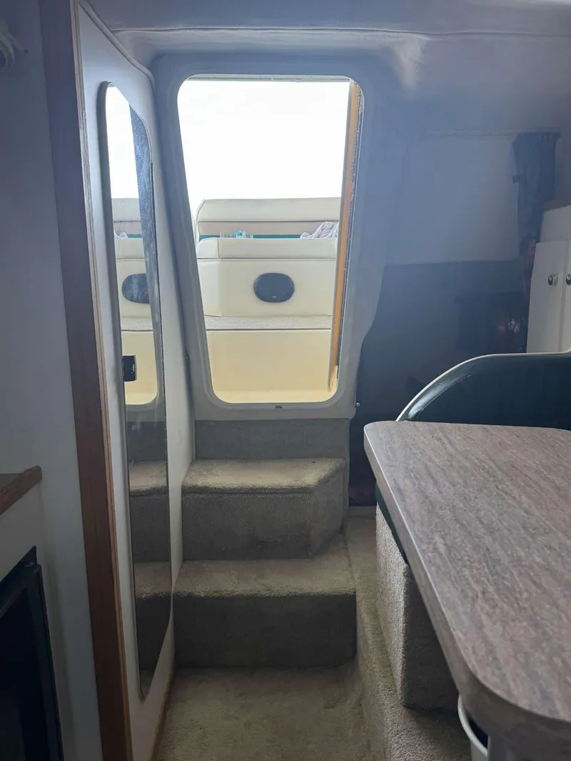 Slide: The Image of Interior view of a 1996 Rinker 280 Fiesta Vee boat, showing stairs and seating area. - 11