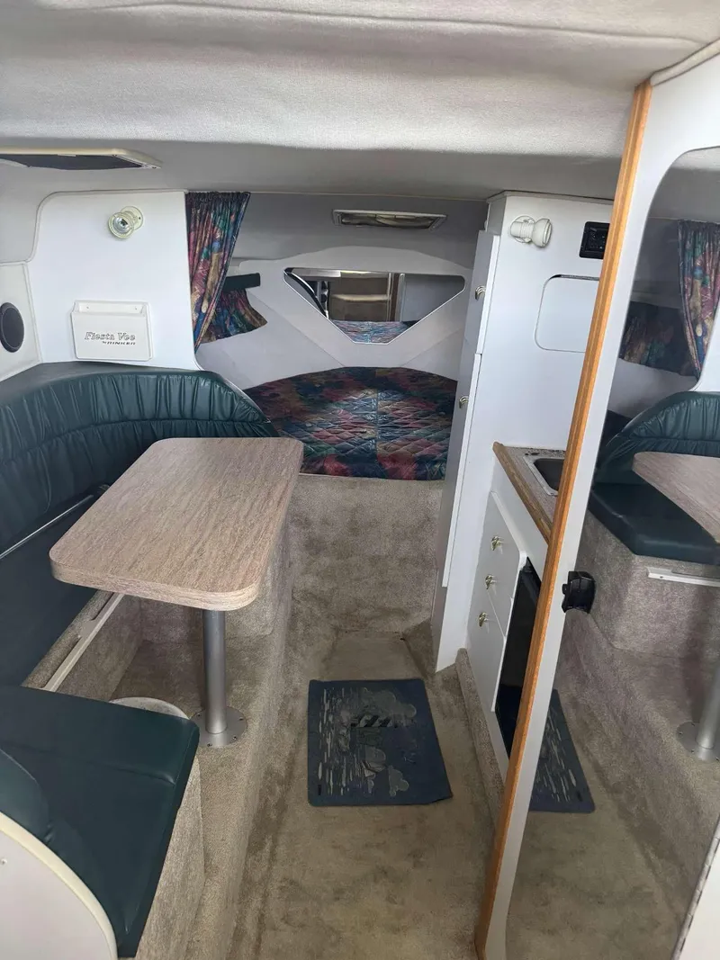 Slide: The Image of Interior of a 1996 Rinker 280 Fiesta Vee boat with seating and table. - 15