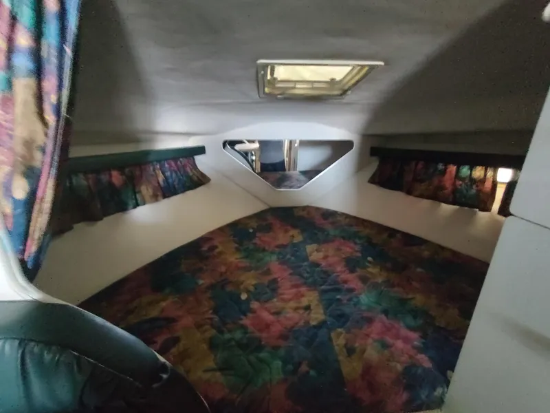 Slide: The Image of Interior cabin of 1996 Rinker 280 Fiesta Vee with colorful bedding and curtains. - 17
