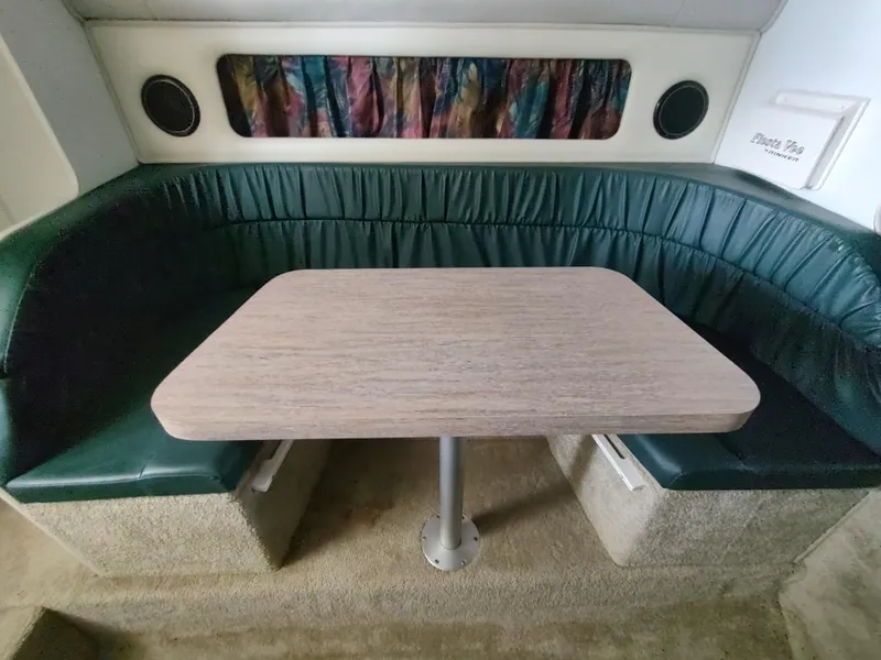 Slide: The Image of 1996 Rinker 280 Fiesta Vee cabin interior with green seating and wooden table. - 19