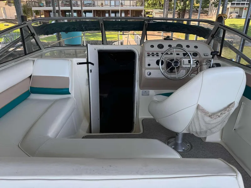 Slide: The Image of Interior of a 1996 Rinker 280 Fiesta Vee boat with white seating and steering console. - 2