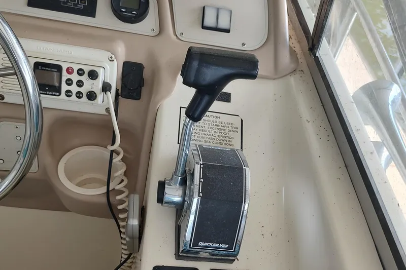 Slide: The Image of 1996 Rinker 280 Fiesta Vee boat control panel with throttle and steering wheel. - 22