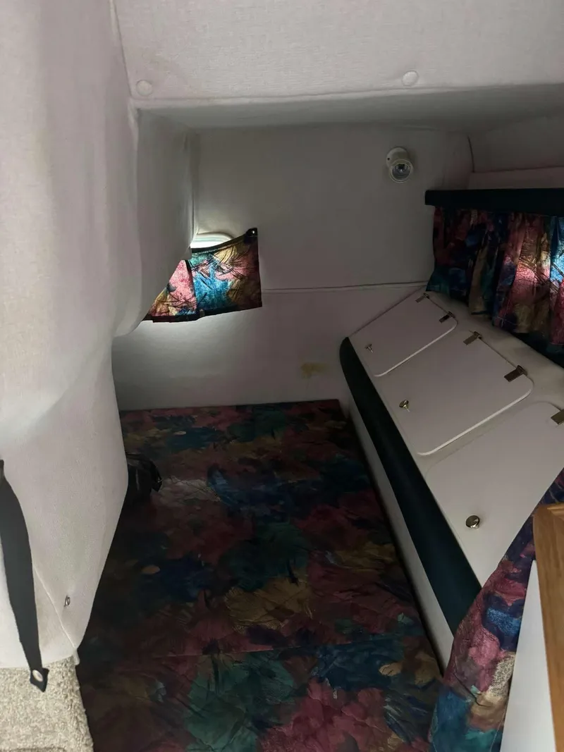 Slide: The Image of Interior cabin of 1996 Rinker 280 Fiesta Vee with colorful decor and compact design. - 3