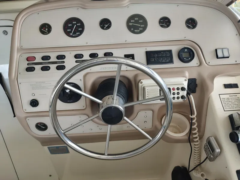 Slide: The Image of 1996 Rinker 280 Fiesta Vee boat dashboard with steering wheel and control panel. - 4