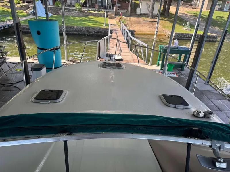 Slide: The Image of 1996 Rinker 280 Fiesta Vee boat docked at a lakeside pier. - 6