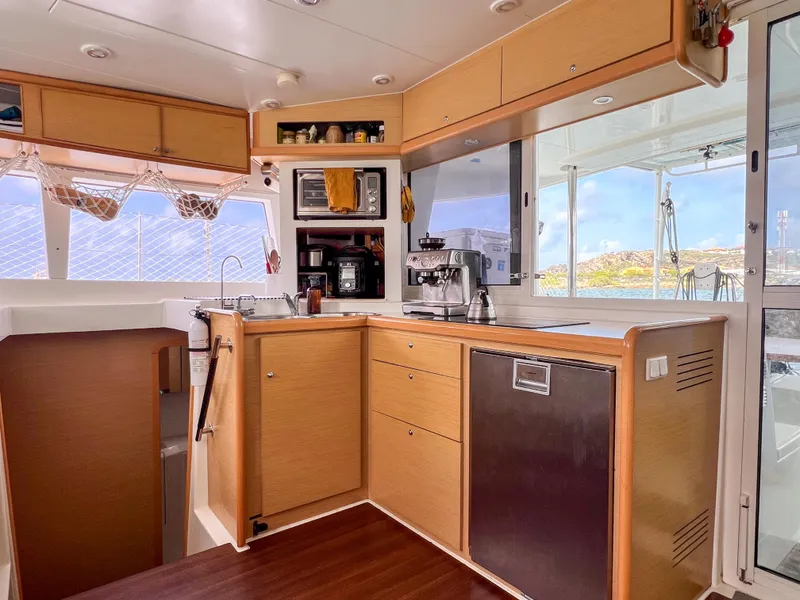 Slide: The Image of Interior of 2011 Lagoon 400 catamaran kitchen with modern appliances and wooden cabinetry. - 12