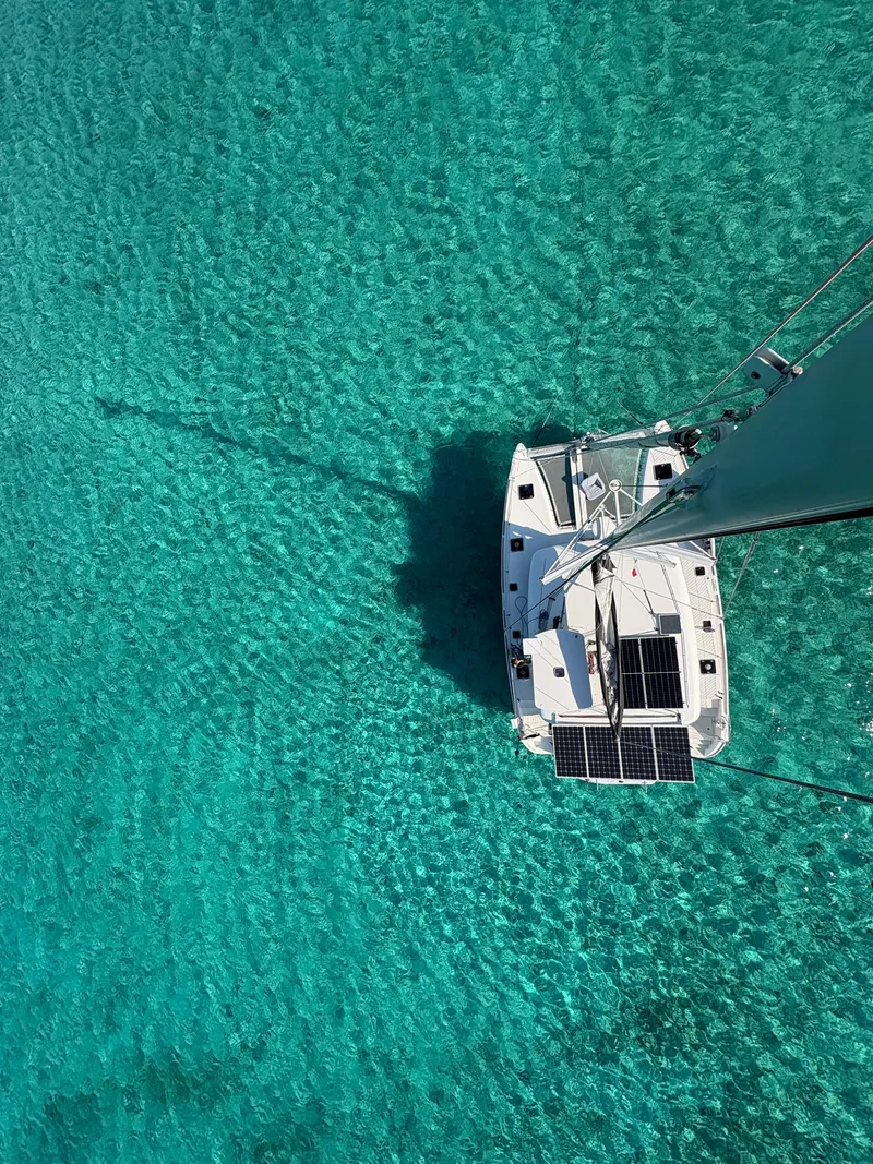 Slide: The Image of Aerial view of 2011 Lagoon 400 catamaran on clear turquoise water. - 15