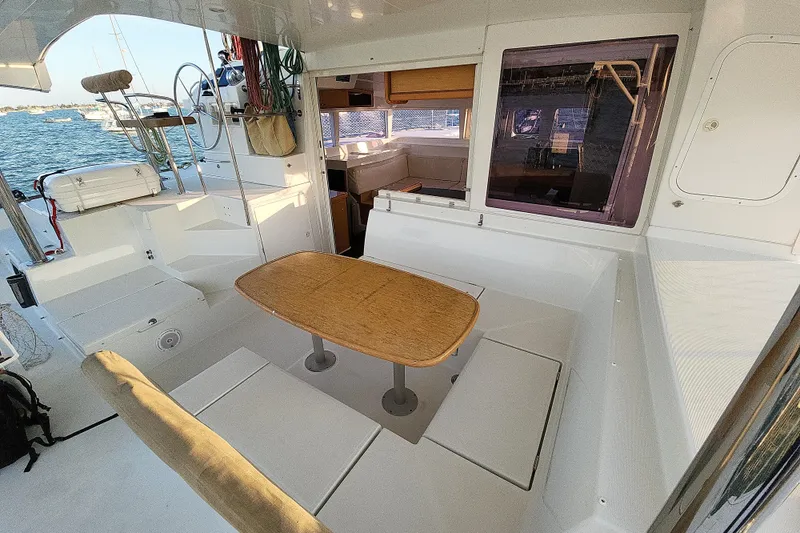 Slide: The Image of Spacious cockpit of 2011 Lagoon 400 catamaran with seating and wooden table. - 27