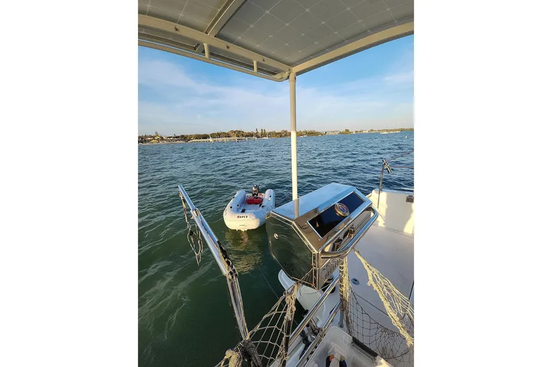 Slide: The Image of Lagoon 400 catamaran, 2011 model, with a small dinghy on calm waters. - 30