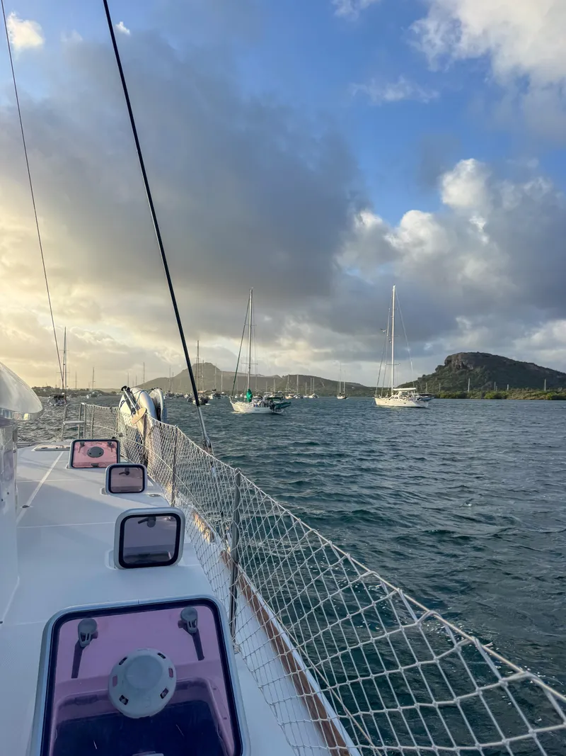 Slide: The Image of Sailing on a 2011 Lagoon 400 catamaran in a scenic bay with moored boats. - 4