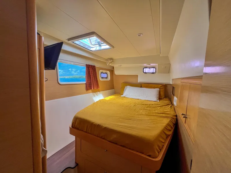 Slide: The Image of Cozy cabin interior of 2011 Lagoon 400 catamaran with bed, window, and TV. - 41