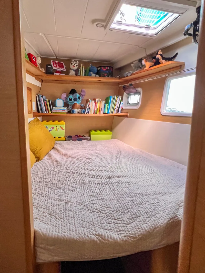Slide: The Image of Cozy cabin bedroom in 2011 Lagoon 400 catamaran with books and plush toys. - 45
