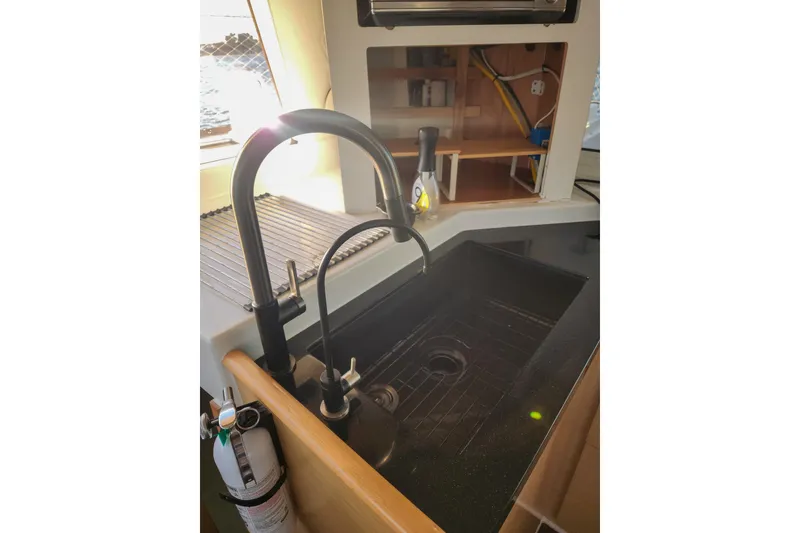 Slide: The Image of Modern kitchen sink in a 2011 Lagoon 400 catamaran, featuring sleek black fixtures. - 50