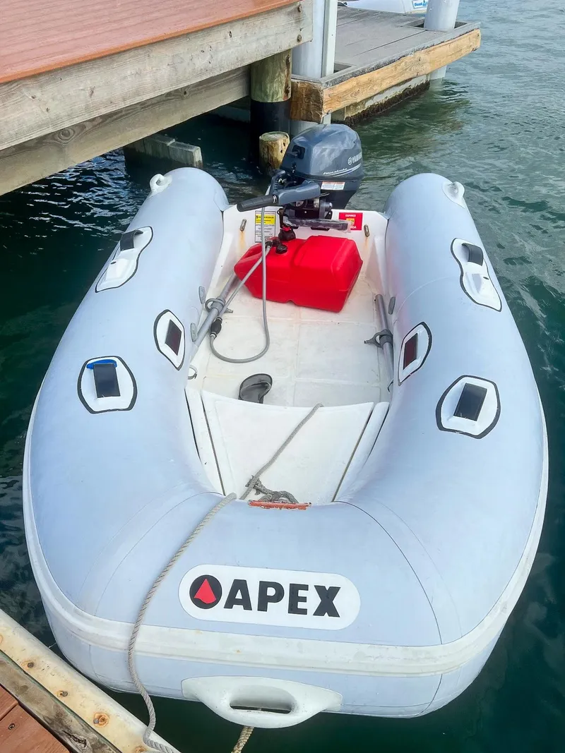 Slide: The Image of Inflatable Apex boat docked, featuring an outboard motor and red fuel tank. - 6